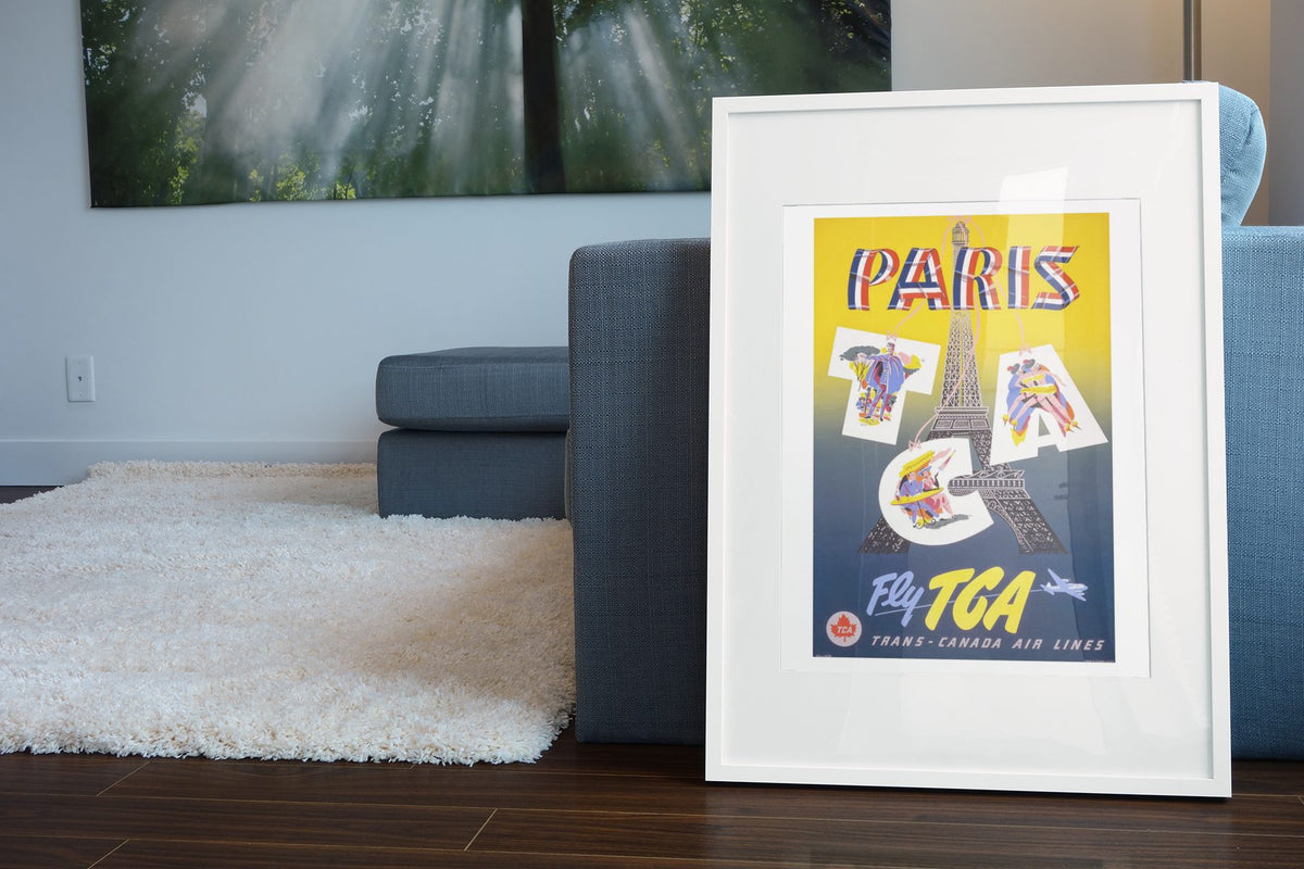 Paris Fly TCA poster leaning beside a blue sofa