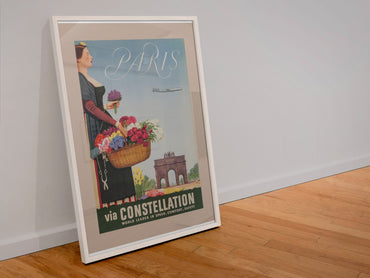 Paris via Constellation poster in a white frame leaning against a wall