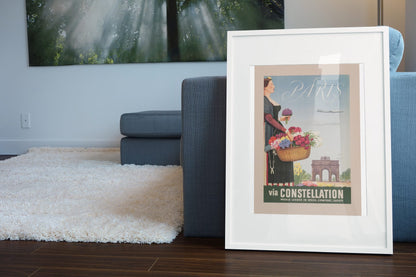 Paris via Constellation poster leaning beside a blue sofa