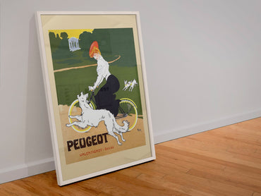Peugeot Bicycles poster in a white frame leaning against a wall