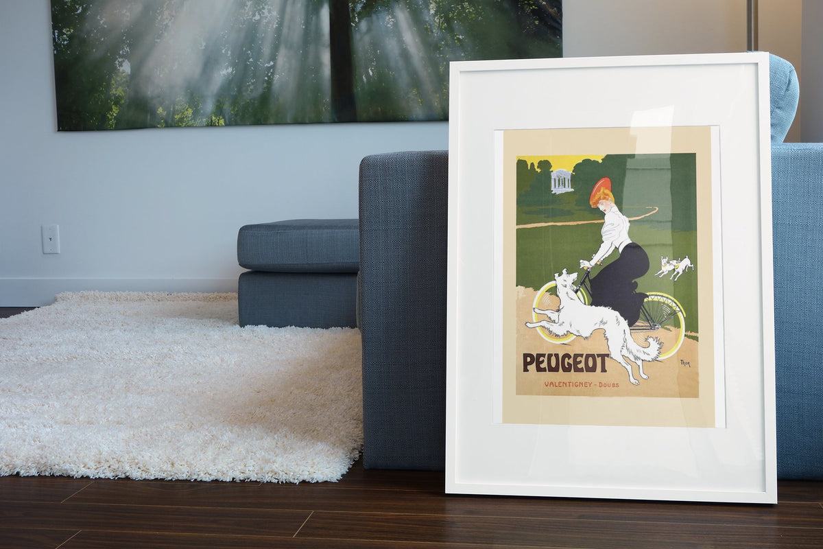 Peugeot Bicycles poster leaning beside a blue sofa