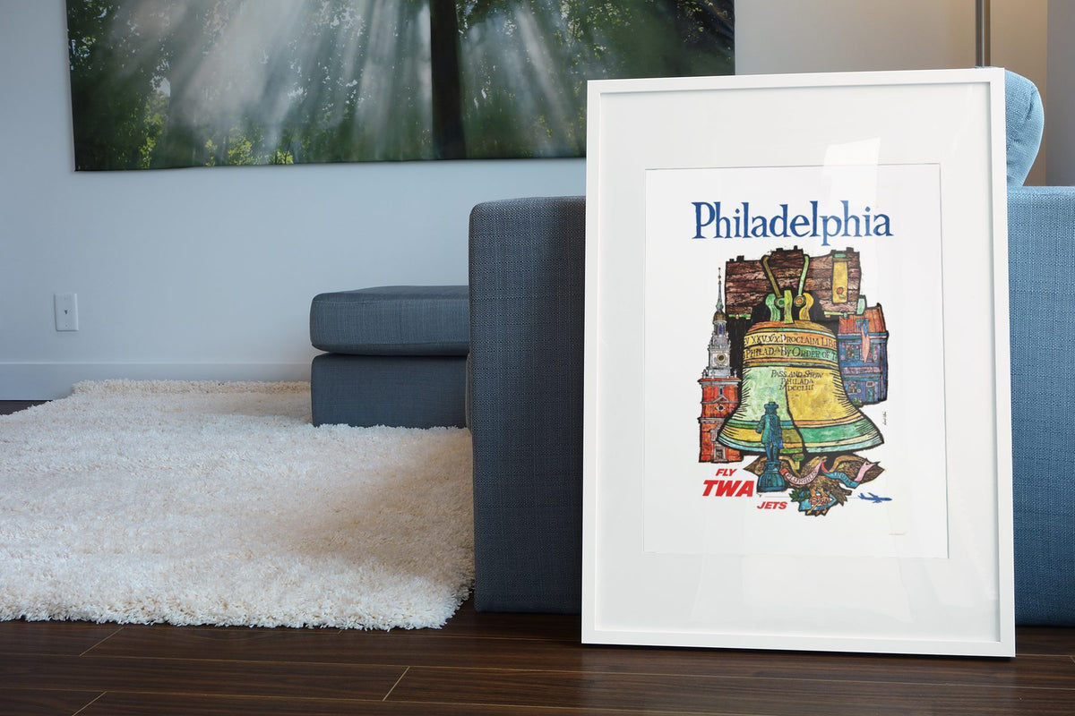 Philadelphia Fly TWA poster leaning beside a blue sofa