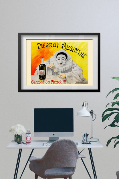 Pierrot Absinthe poster framed on a grey wall above a desk