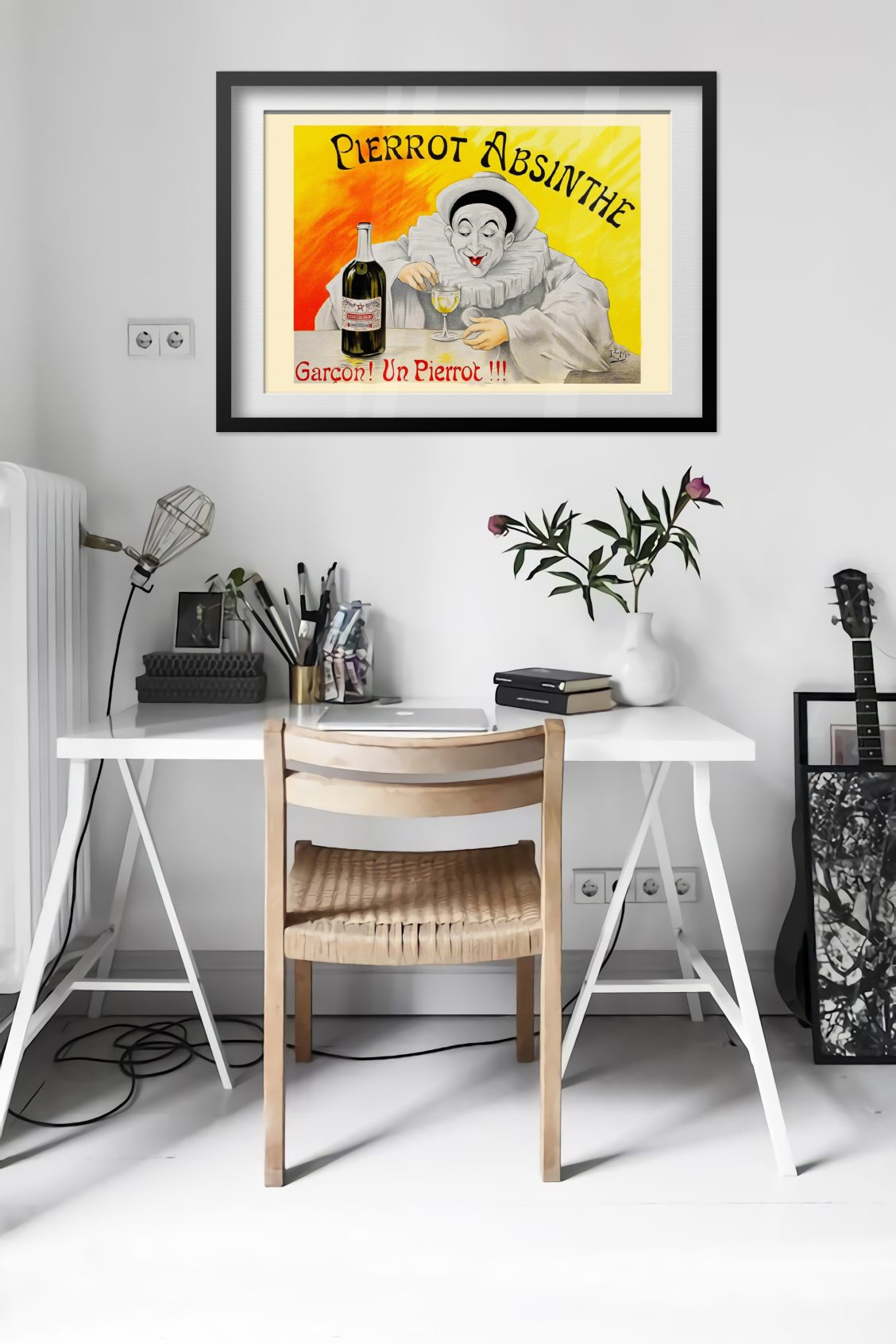 Pierrot Absinthe poster framed above a desk in a bright white room