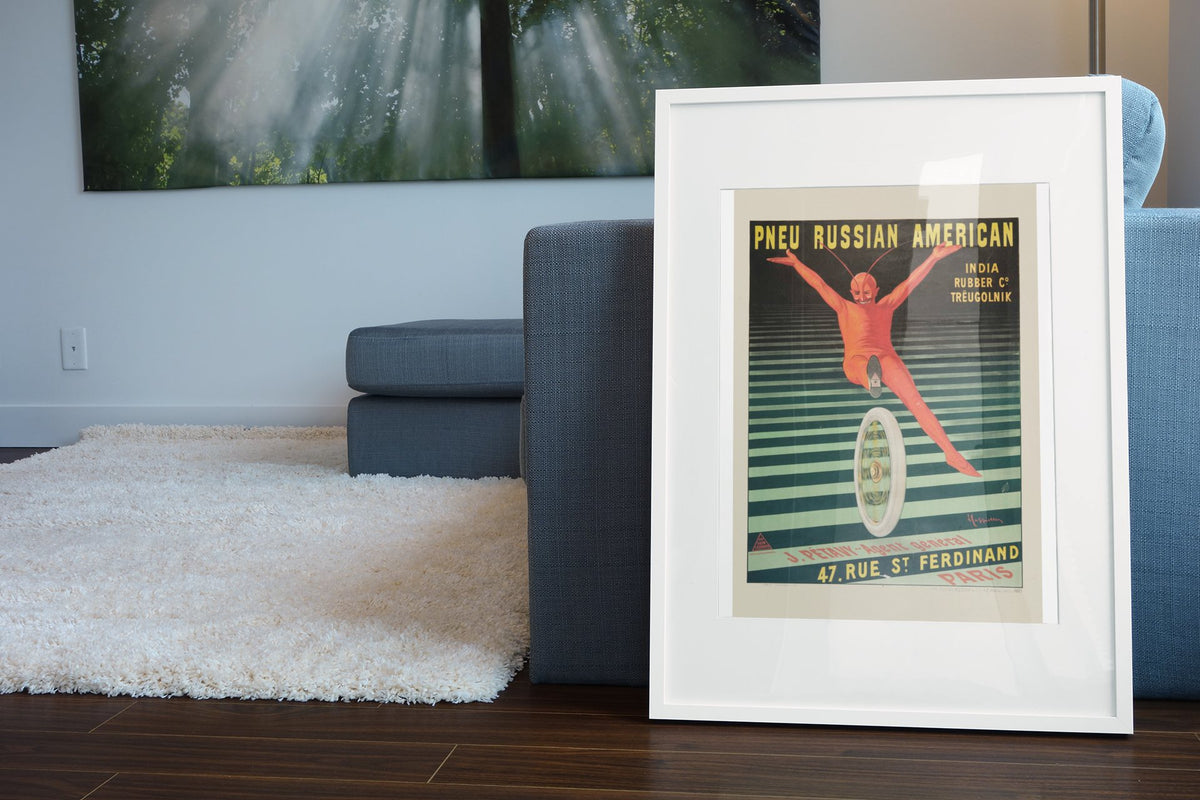 Pneu Russian American poster leaning beside a blue sofa