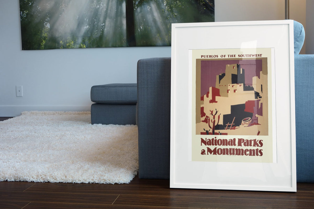 Pueblos of the Southwest National Parks poster leaning beside a blue sofa