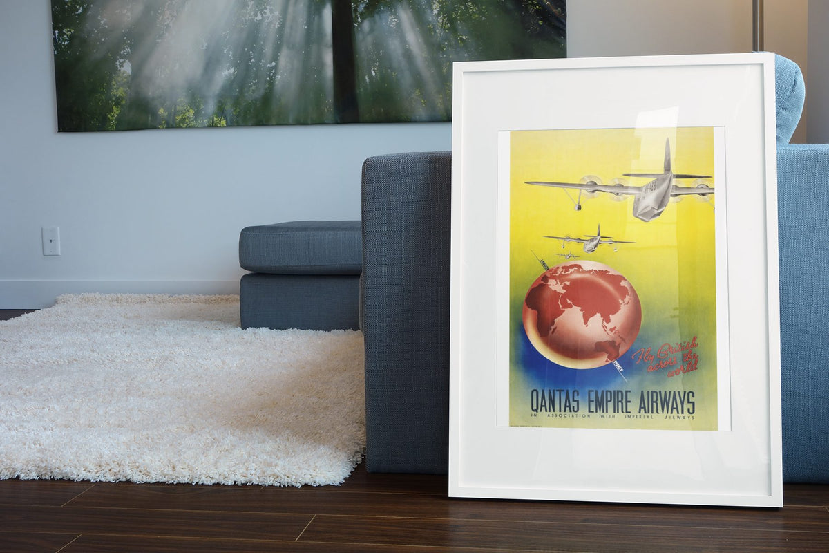 Qantas Empire Airways poster leaning beside a blue sofa