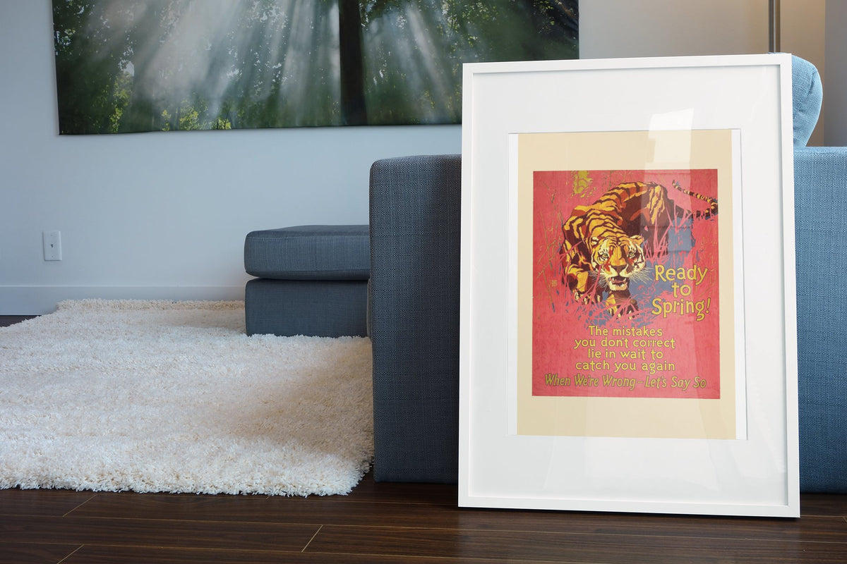 Ready to Spring poster in a white frame leaning beside a blue sofa