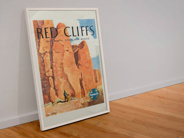 Red Cliffs New Mexico Santa Fe poster in a white frame leaning against a wall