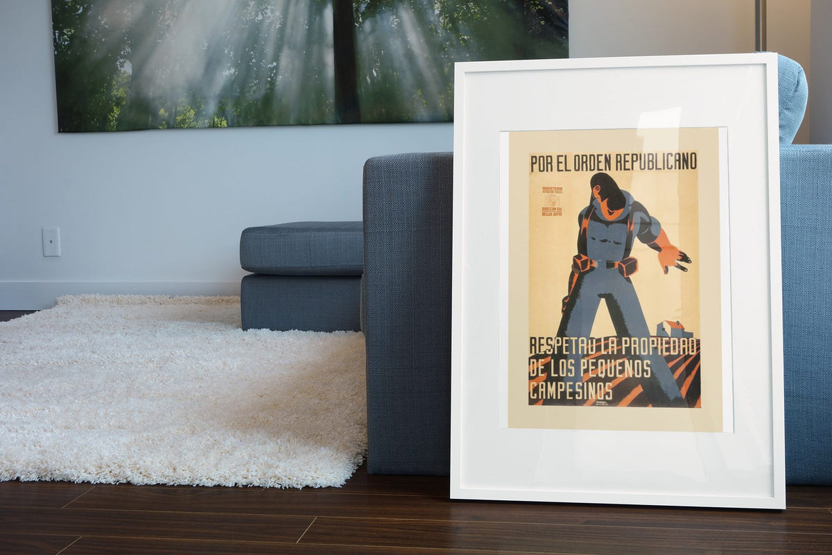 Respect the Small Farmer poster leaning beside a blue sofa