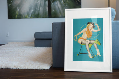 Ride Em Cowgirl poster leaning beside a blue sofa