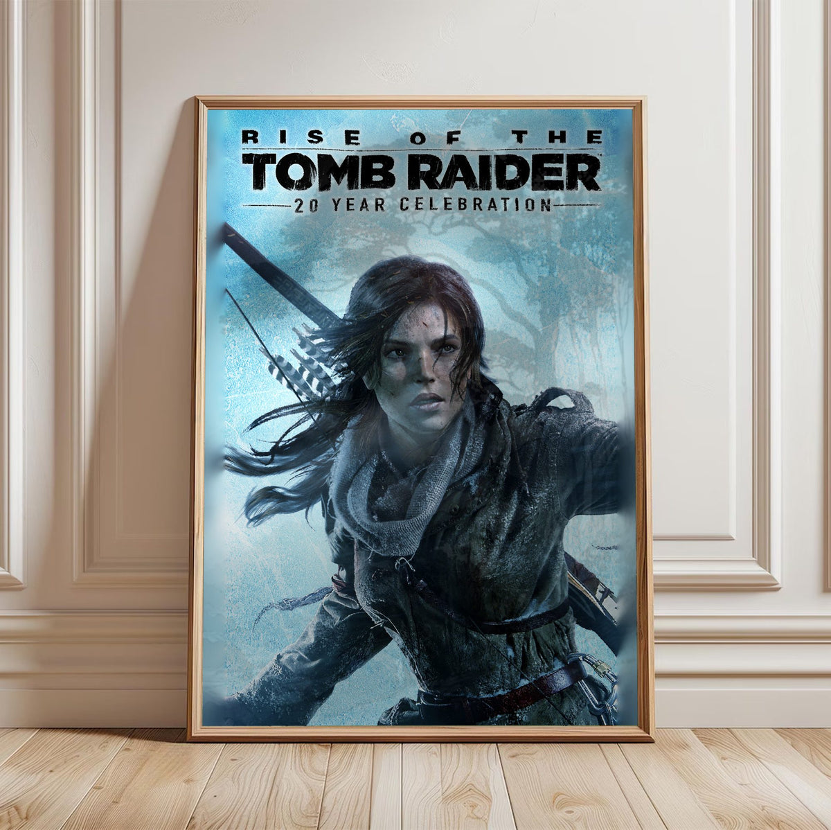 Rise of the Tomb Raider 20 Year Celebration Art poster in a light oak frame leaning against a white wall