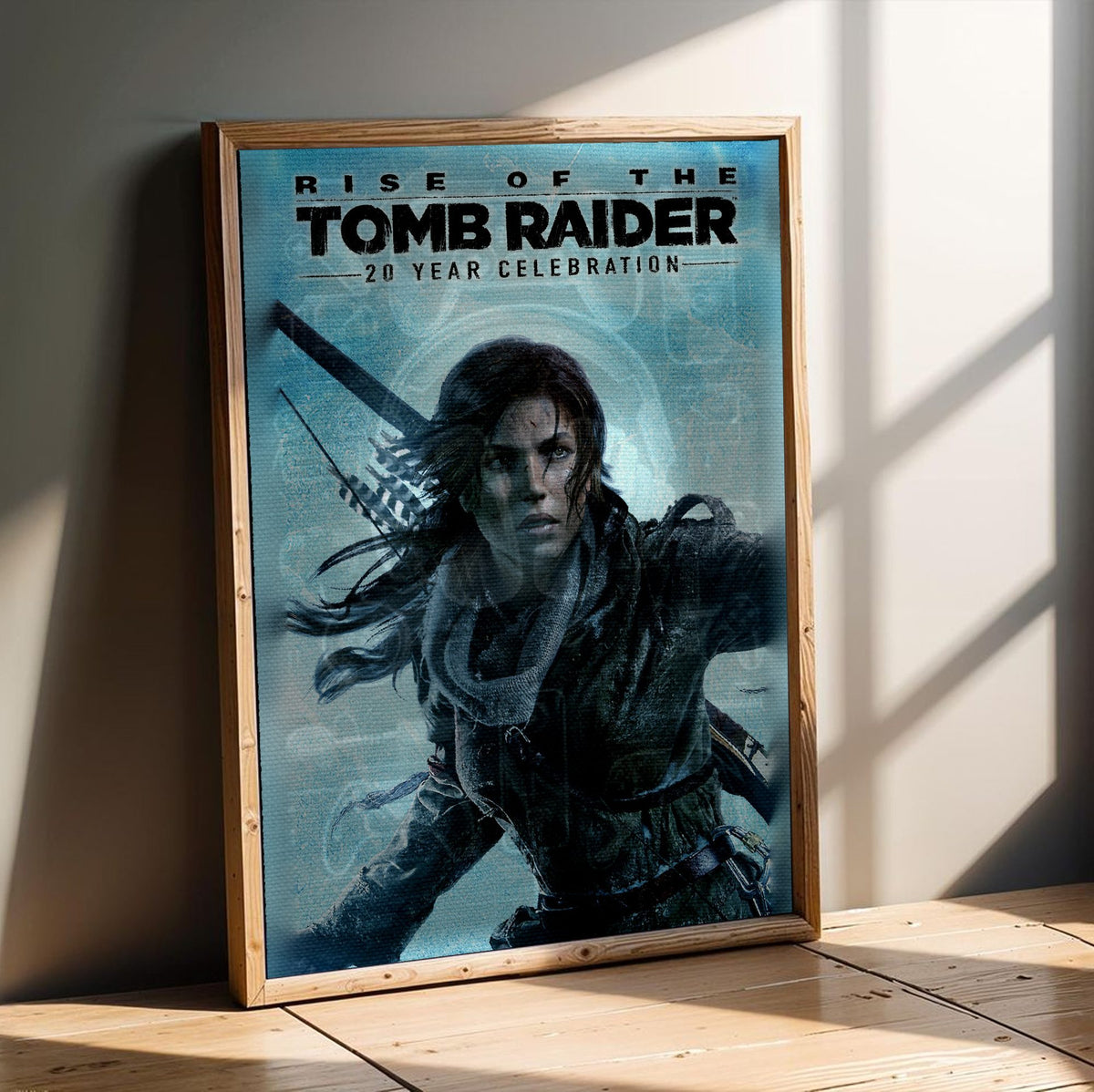 Rise of the Tomb Raider 20 Year Celebration Art poster in an oak frame leaning on a wooden floor