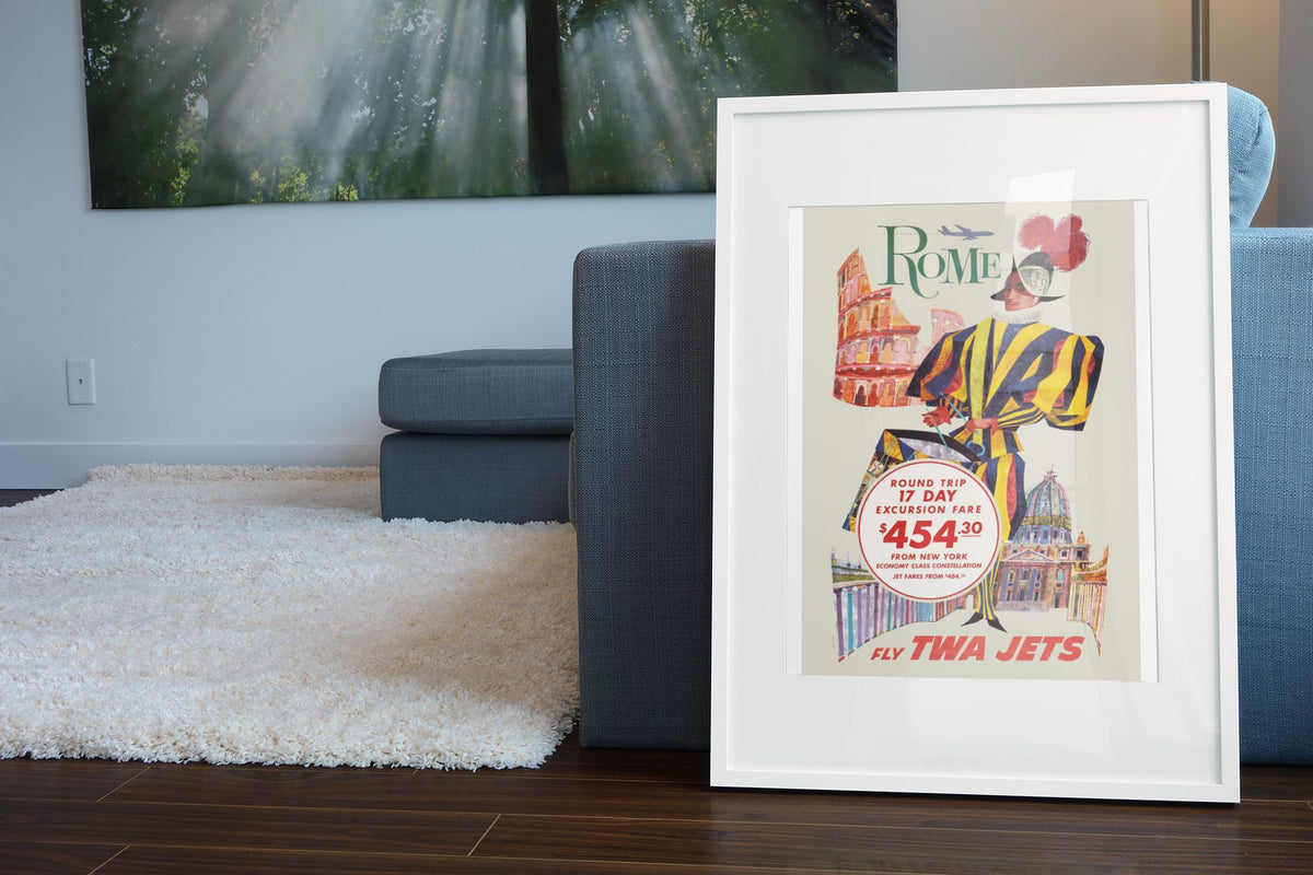 Rome Fly TWA Jets poster leaning beside a blue sofa