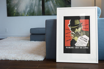 Rumors Cost Us Lives poster leaning beside a blue sofa