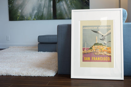 San Francisco American Airlines poster leaning beside a blue sofa