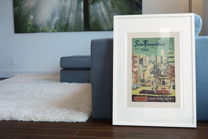San Francisco Fly TWA Cable Car poster leaning beside a blue sofa