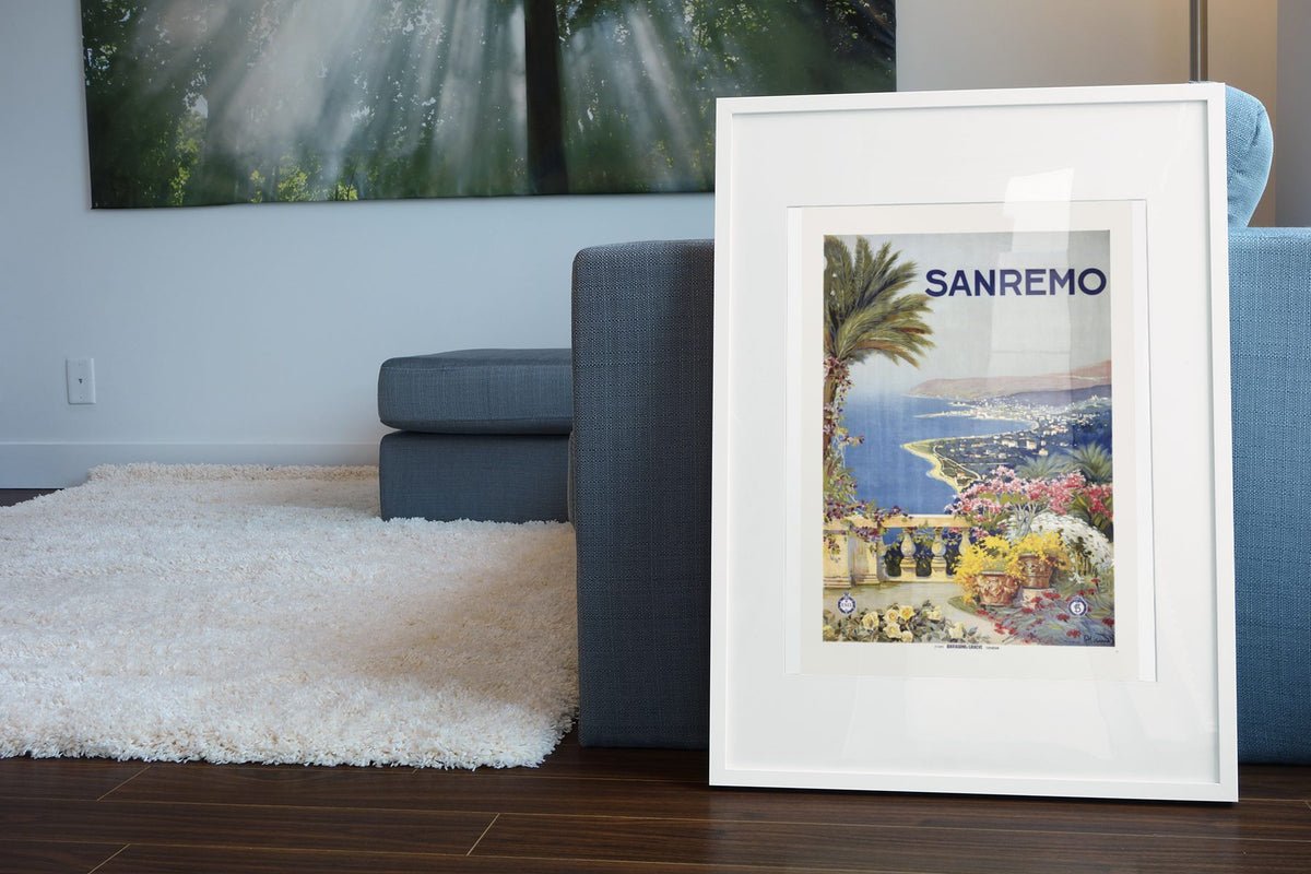 Sanremo — Italian Riviera poster leaning beside a blue sofa