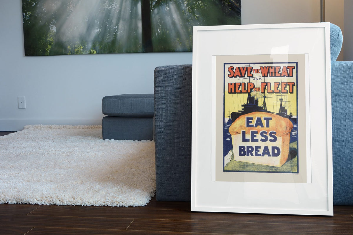 Save the Wheat Help the Fleet Eat Less Bread poster leaning beside a blue sofa