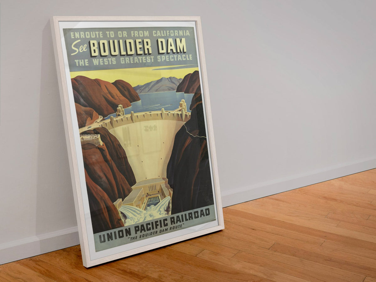 See Boulder Dam Union Pacific poster in a white frame leaning against a wall