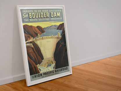 See Boulder Dam Union Pacific poster in a white frame leaning against a wall
