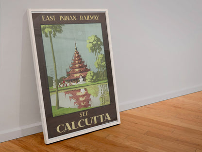See Calcutta — East Indian Railway poster in a white frame leaning against a wall