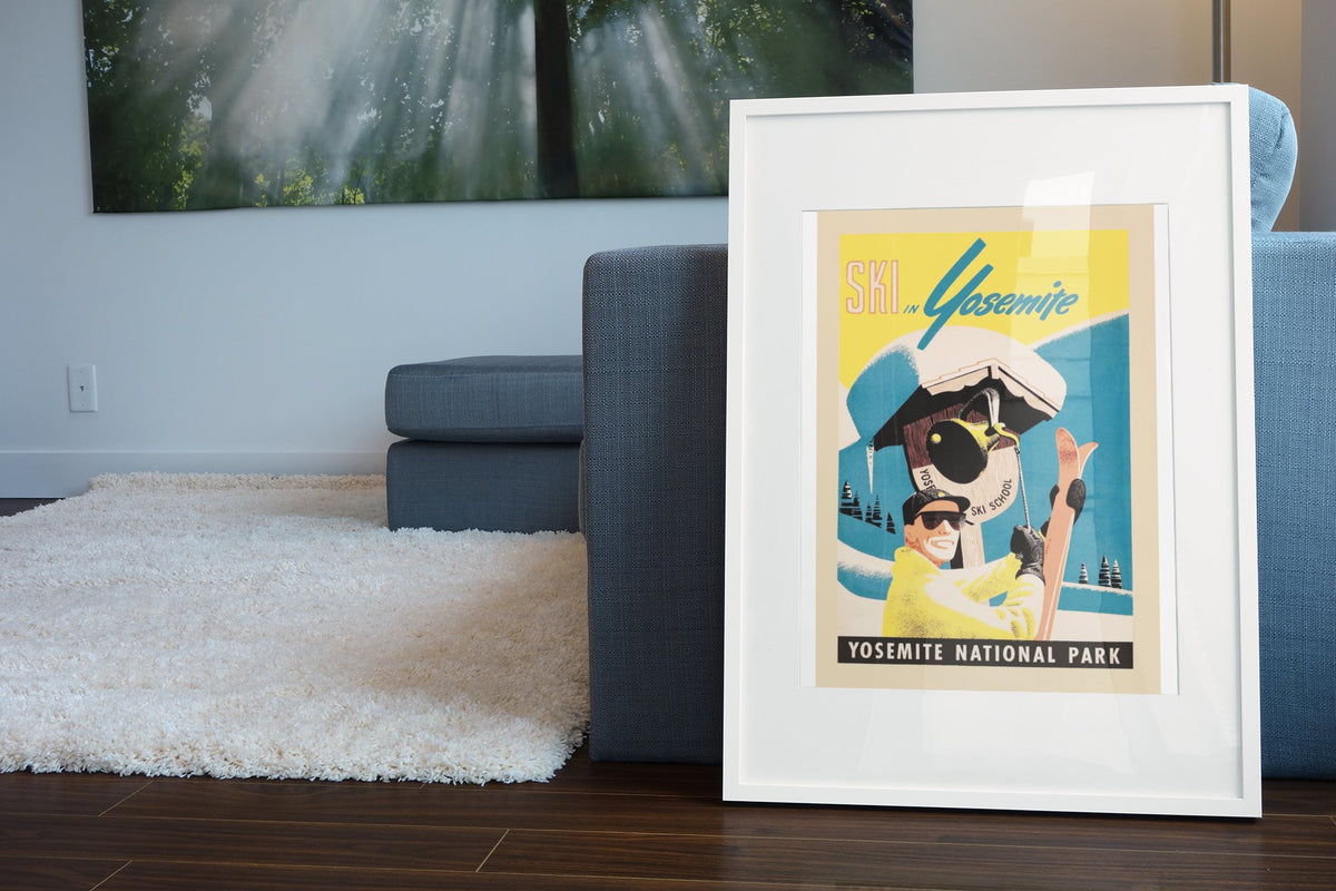 Ski in Yosemite poster leaning beside a blue sofa