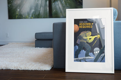 Some User Assembly Required poster in a white frame leaning beside a blue sofa