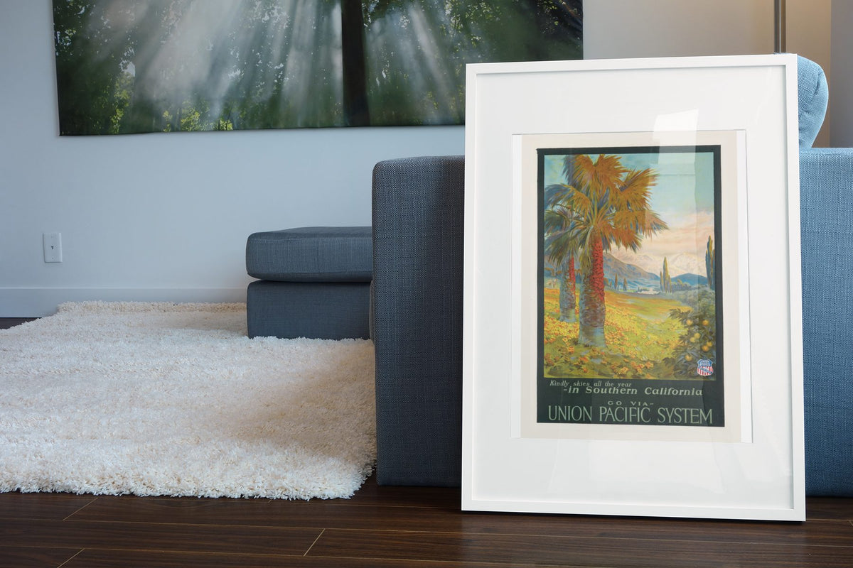 Southern California Union Pacific poster leaning beside a blue sofa