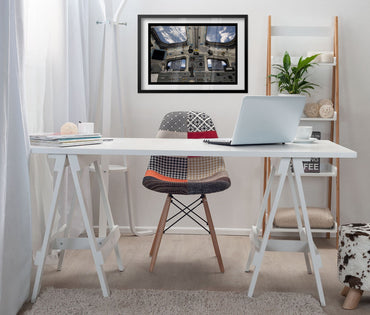 Space Shuttle Atlantis cockpit poster framed above a white desk
