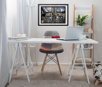 Space Shuttle Atlantis cockpit poster framed above a white desk