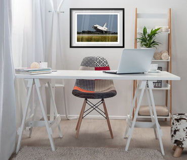 Space Shuttle Atlantis landing poster framed above a white desk