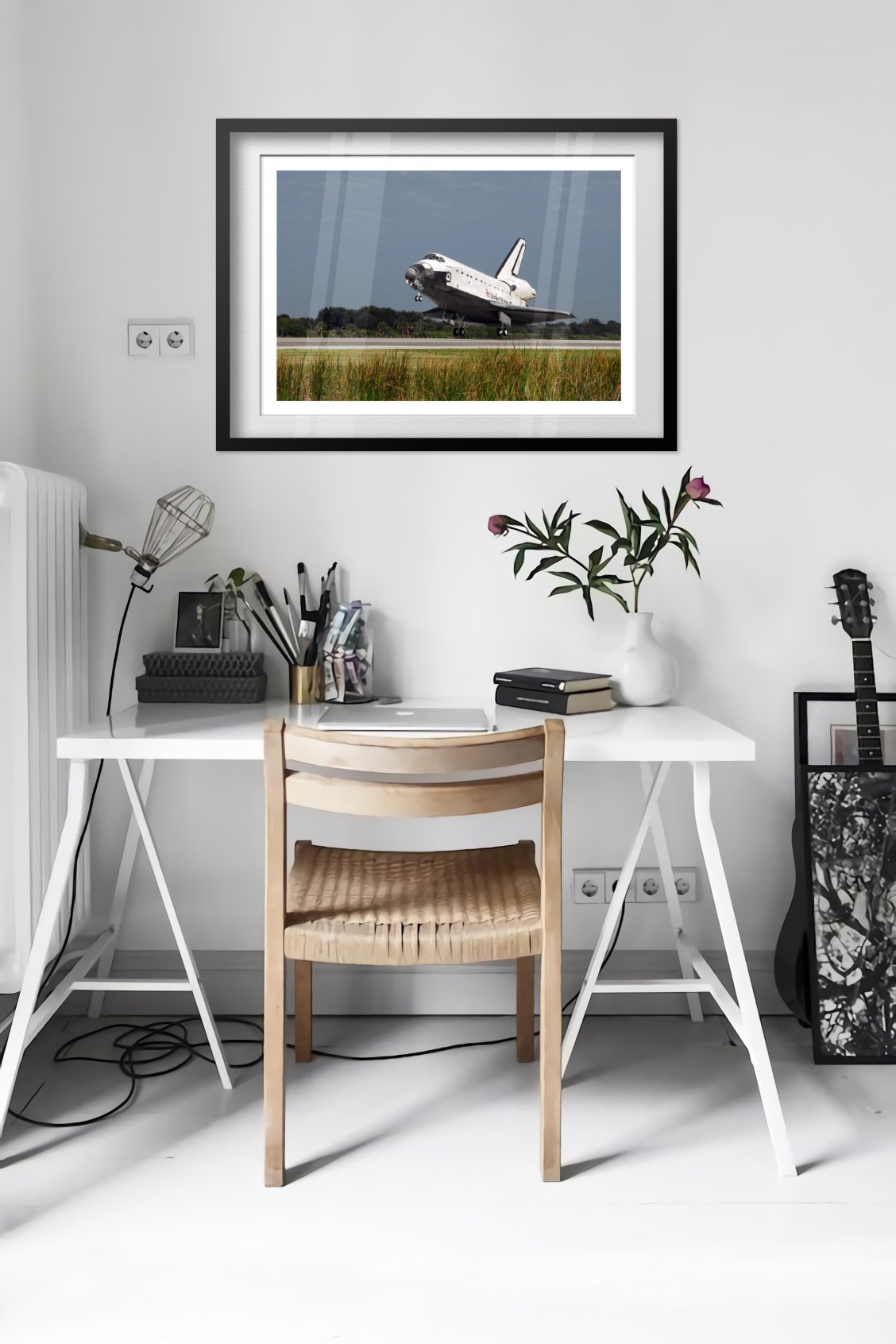 Space Shuttle Atlantis landing poster framed in a bright home office
