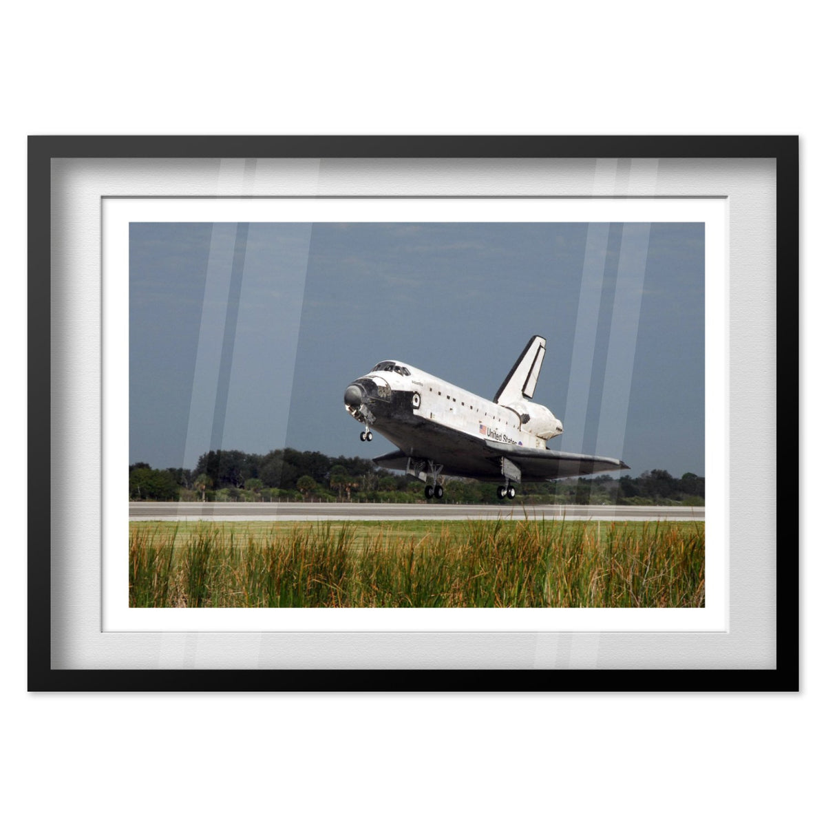 Space Shuttle Atlantis landing poster in a black frame