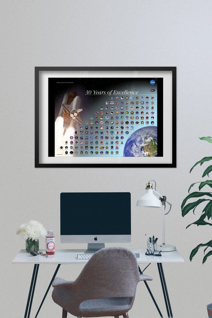 Space Shuttle mission patches, 30 Years of Excellence poster framed above a desk with a computer