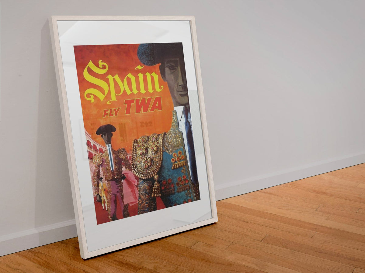 Spain Fly TWA poster in a white frame leaning against a wall