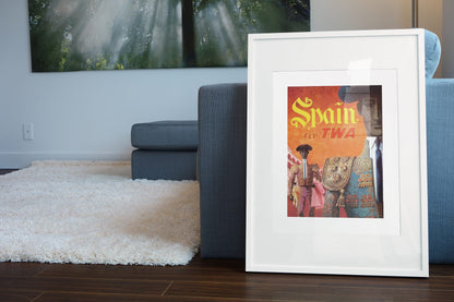 Spain Fly TWA poster leaning beside a blue sofa