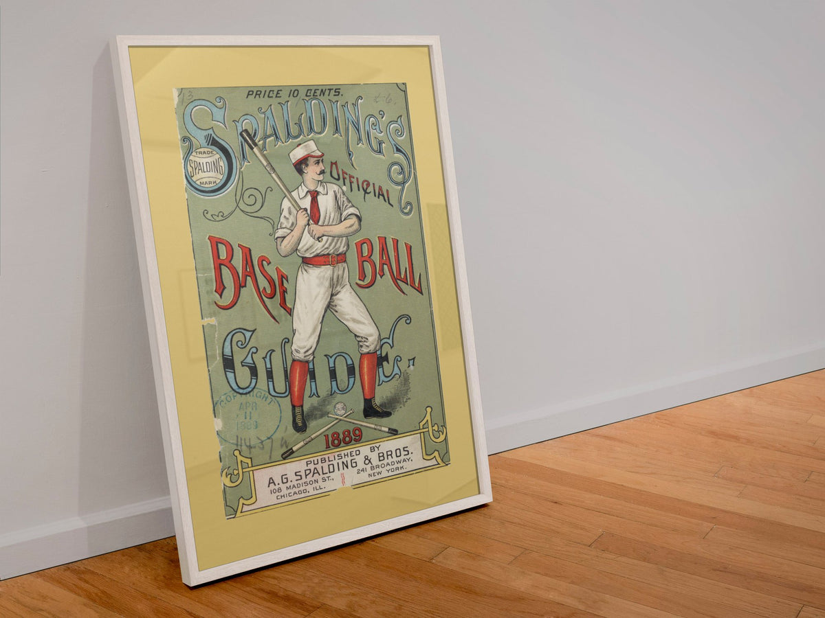 Spalding Base Ball Guide 1889 poster in a white frame leaning against a wall