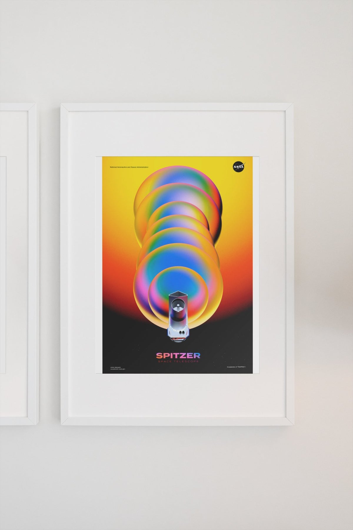 Spitzer Space Telescope poster in a white frame on a light wall