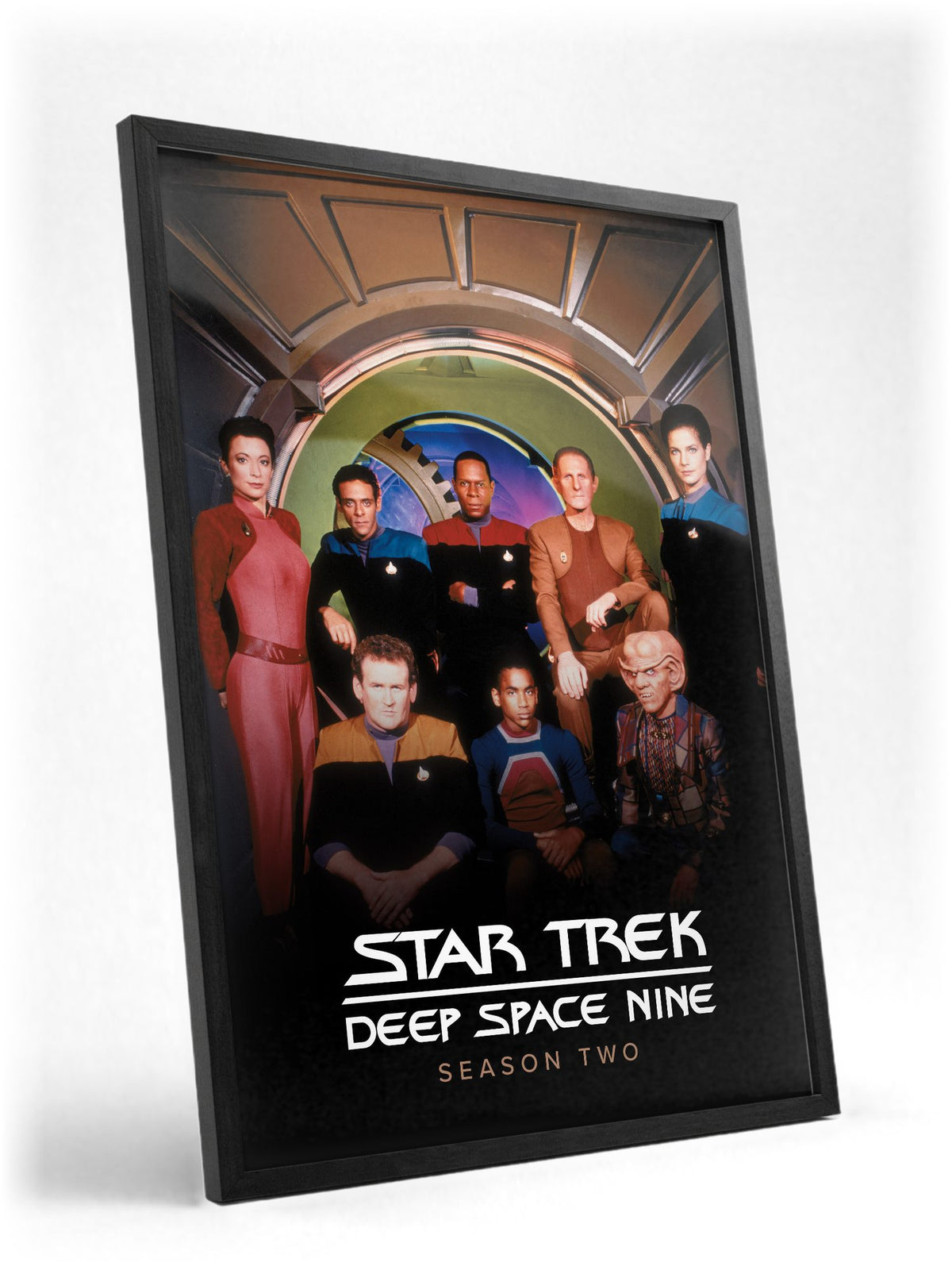Star Trek: Deep Space Nine poster in a black frame with glass leaning against a wall