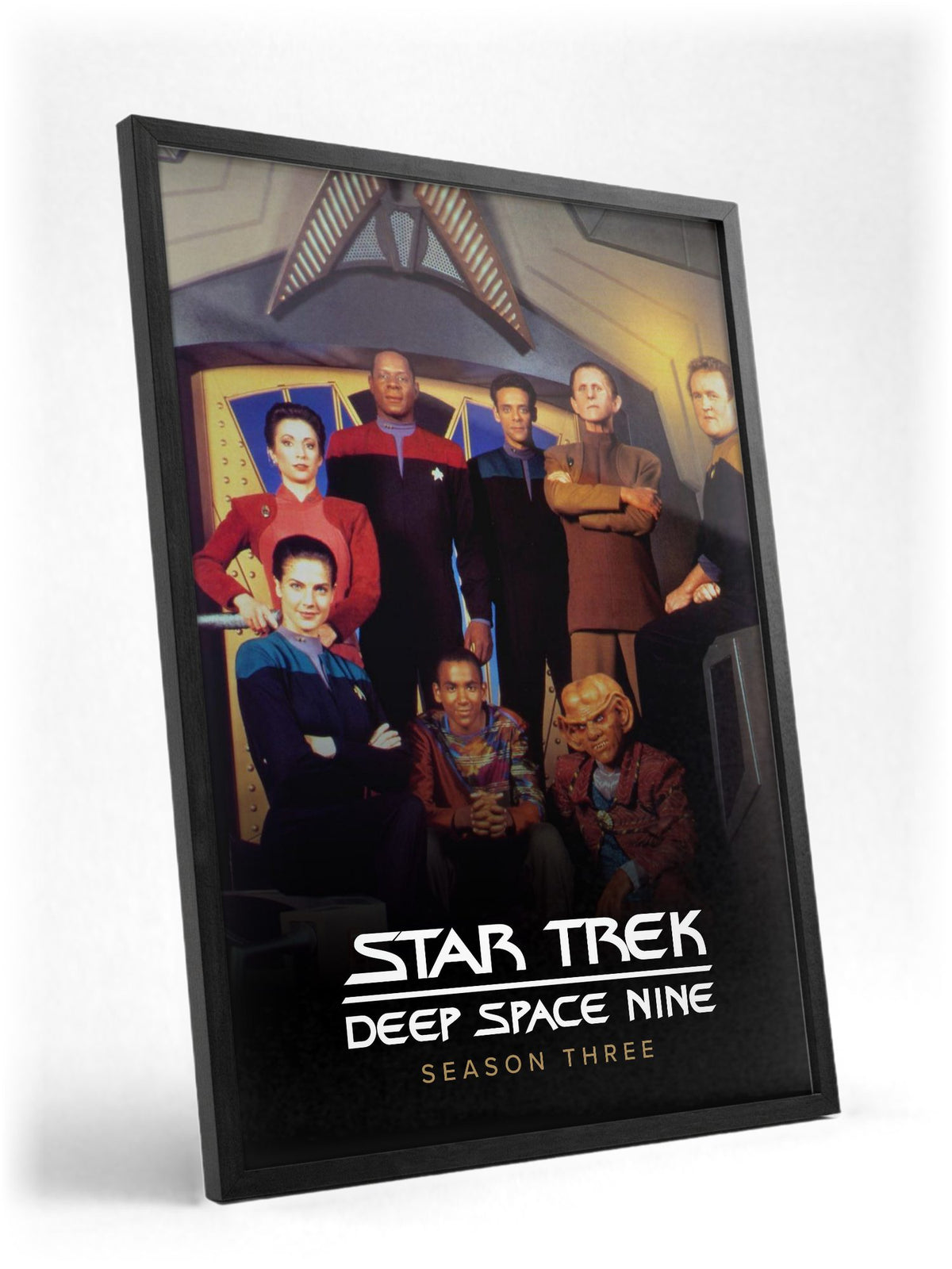 Star Trek: Deep Space Nine poster in a black frame with glass leaning against a wall