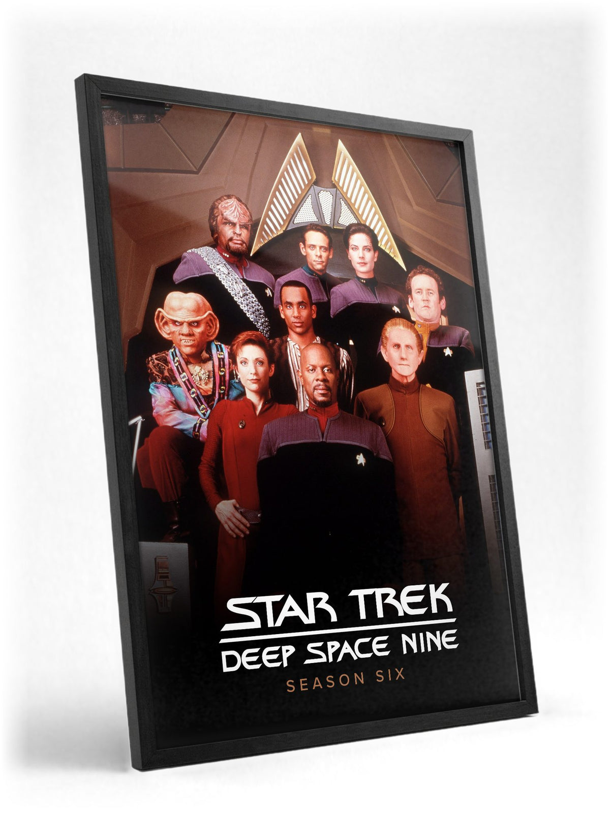 Star Trek: Deep Space Nine poster in a black frame with glass leaning against a wall