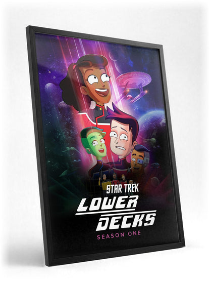Star Trek: Lower Decks poster in a black frame with glass leaning against a wall