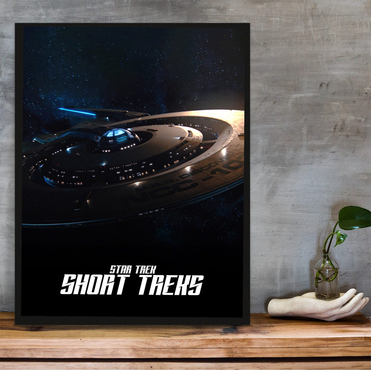 Star Trek: Short Treks poster in a black frame on a wooden shelf against concrete