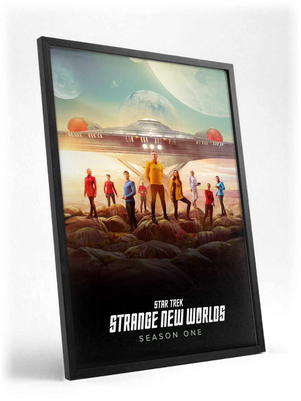 Star Trek: Strange New Worlds poster in a black frame with glass leaning against a wall