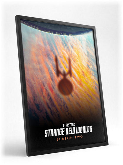 Star Trek: Strange New Worlds poster in a black frame with glass leaning against a wall