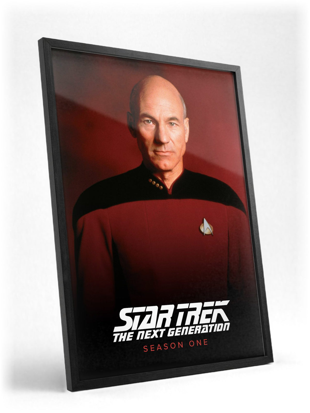 Star Trek: The Next Generation poster in a black frame with glass leaning against a wall