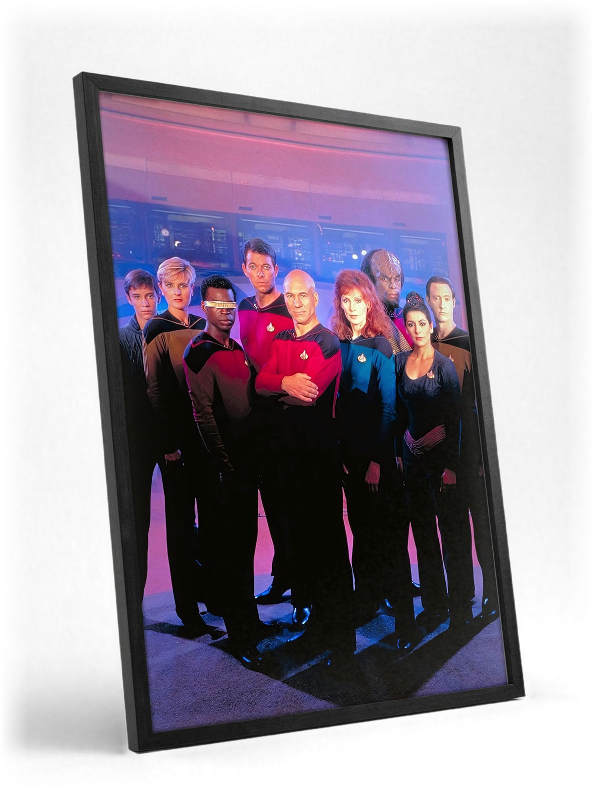 Star Trek: The Next Generation poster in a black frame with glass leaning against a wall