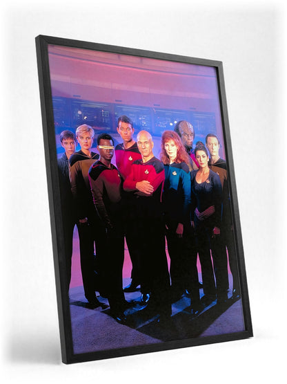 Star Trek: The Next Generation poster in a black frame with glass leaning against a wall