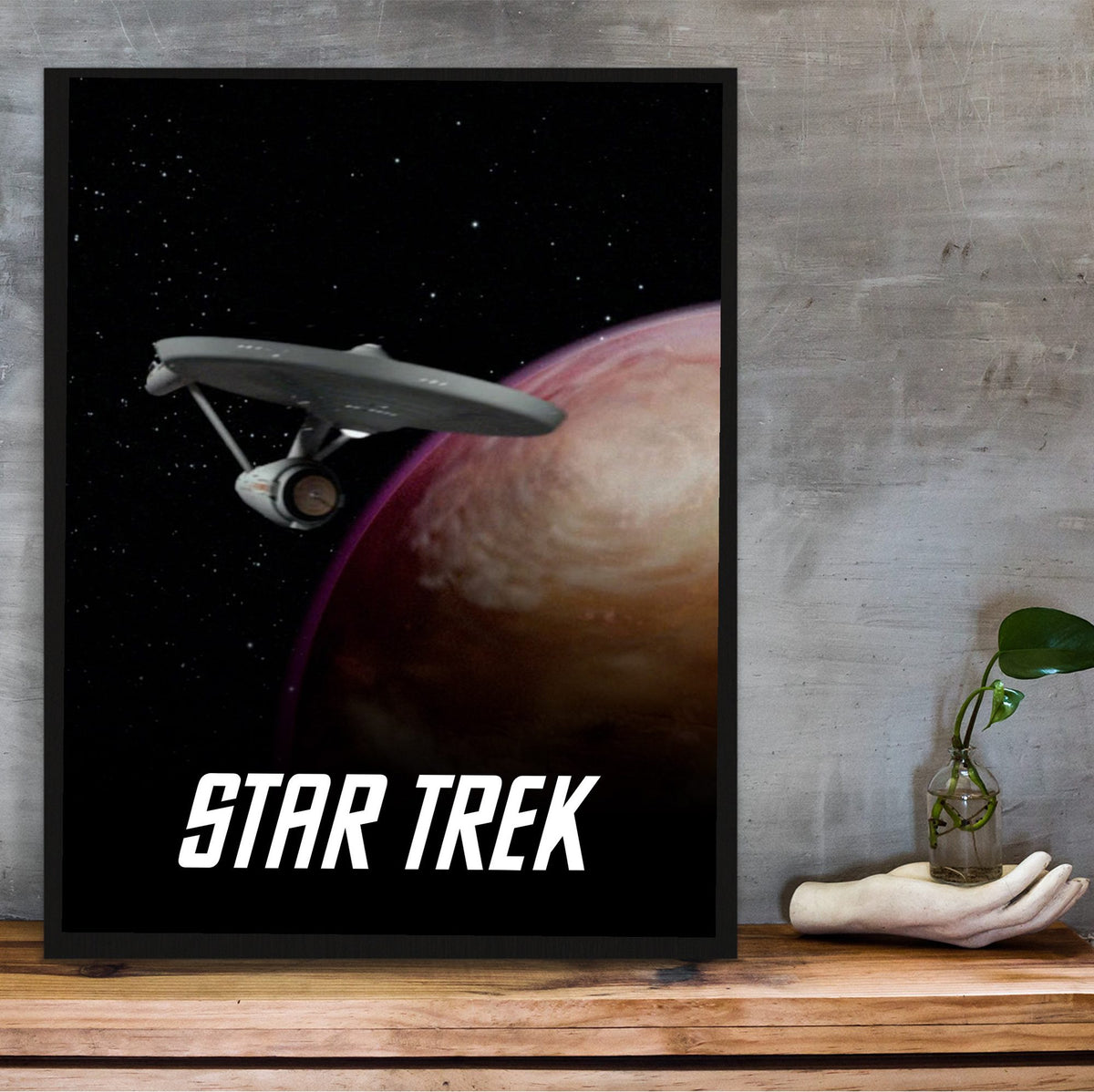 Star Trek: The Original Series poster in a black frame on a wooden shelf against concrete